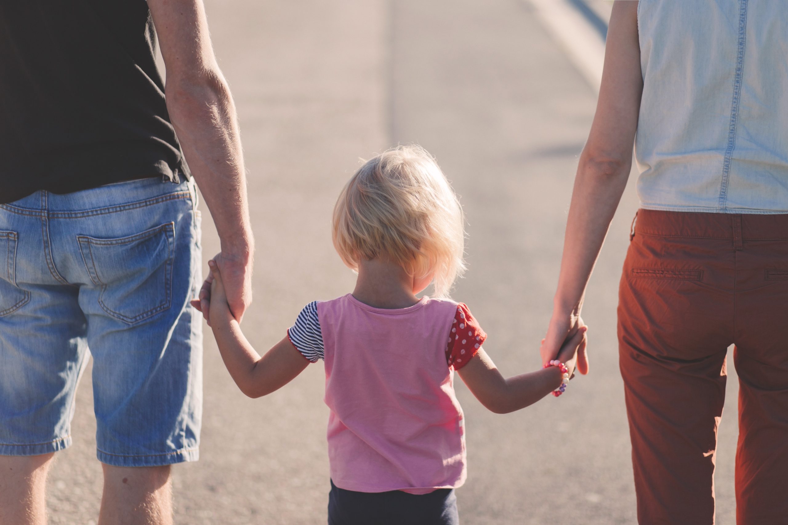 child holding hands with parents